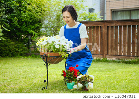 一位微笑的中年婦女正在種樹 一位微笑的中年婦女正在種樹 116047031