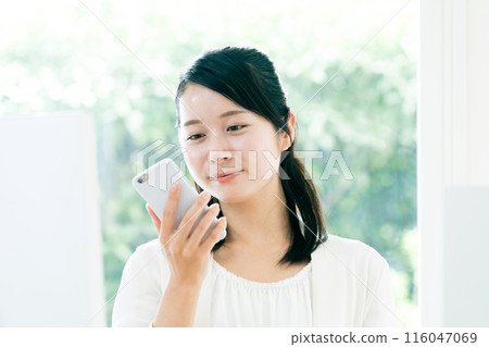 A woman watching a smartphone A woman watching a smartphone 116047069