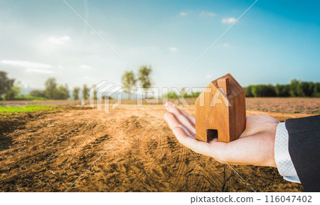 House symbol with location pin on Empty dry cracked swamp reclamation soil, land plot for housing construction project, property investment concept, Buying new home for family. House symbol with location pin on Empty dry cracked swamp reclamation soil, land plot for housing construction project, property investment concept, Buying new home for family. 116047402