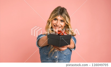Happy transgender woman offering small gift box against pink background Happy transgender woman offering small gift box against pink background 116049705