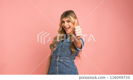 Contented transgender woman looking at camera and showing thumbs up Contented transgender woman looking at camera and showing thumbs up 116049720