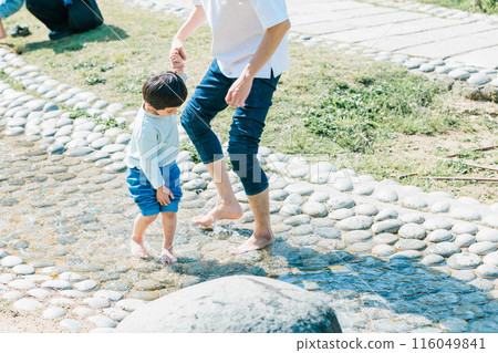 一個男孩和他的父親在公園的小溪玩水 一個男孩和他的父親在公園的小溪玩水 116049841