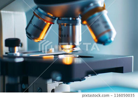 This image shows a close-up view of a microscope with illuminated lenses and a glass slide, by Generative AI This image shows a close-up view of a microscope with illuminated lenses and a glass slide, by Generative AI 116050035