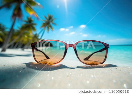 Close-Up of Sunglasses on a Sunny Tropical Beach With Clear Blue Sky 116050918