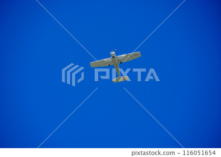 A light aircraft gliding through the blue sky 116051654