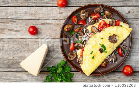 Omelette stuffed with mushrooms , tomatoes and parsley 116052208