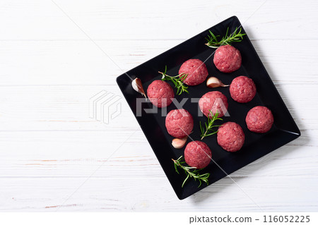 Raw beef meatballs on wooden background 116052225