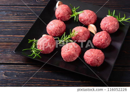 Raw beef meatballs on wooden background 116052226