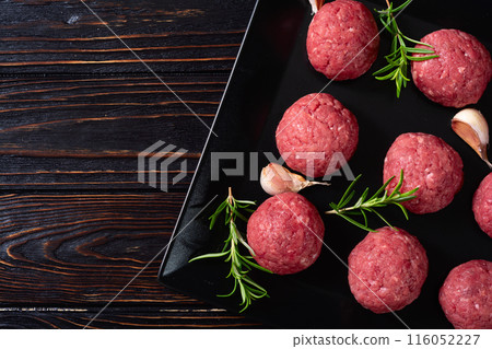 Raw beef meatballs on wooden background Raw beef meatballs on wooden background 116052227