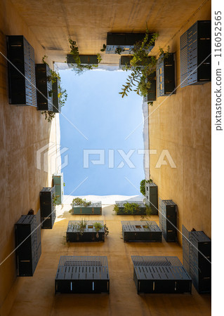 View up into the sky from the courtyard well in Barcelona, Spain. Bottom view. Modern balcony with plants 116052565