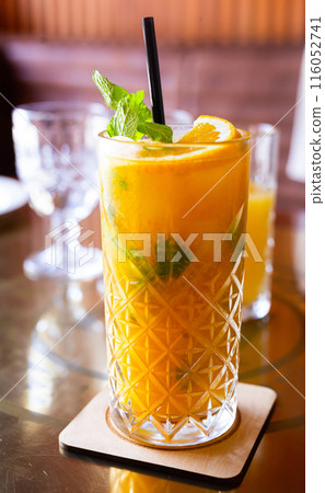 Non alcoholic sea buckthorn cocktail with mint and orange in a glass glass Non alcoholic sea buckthorn cocktail with mint and orange in a glass glass 116052741