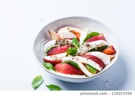 Caprese salad with peach, basil and mozzarella, white background. Caprese salad with peach, basil and mozzarella, white background. 116053598