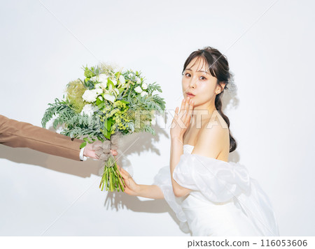 A woman in a wedding dress is happy to receive a bouquet. Bridal photo. Pre-wedding photo shoot. A woman in a wedding dress is happy to receive a bouquet. Bridal photo. Pre-wedding photo shoot. 116053606