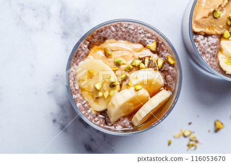 Chocolate chia pudding with banana, pistachio and maple syrup. 116053670