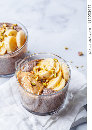 Chocolate chia pudding with banana, pistachio and maple syrup. 116053671