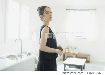 A woman standing in front of the kitchen 116055563
