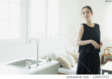 A woman standing in front of the kitchen 116055572