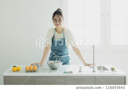Young woman standing in the kitchen Young woman standing in the kitchen 116055643