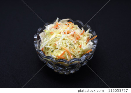 Vegetable salad in a glass salad bowl on a black background. A portion of vegetable salad. Vegetable salad in a glass salad bowl on a black background. A portion of vegetable salad. 116055737