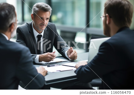 A group of business people in blazers are sharing papers at an event 116056470