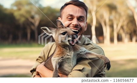 A man is holding a kangaroo in his arms 116056677