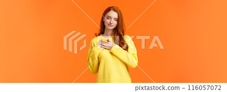 Tender and romantic, lovely young modern redhead woman 20s, touch heart and close eyes, remember dearest, touching moment, recall perfect date, keep memories in soul, orange background Tender and romantic, lovely young modern redhead woman 20s, touch heart and close eyes, remember dearest, touching moment, recall perfect date, keep memories in soul, orange background 116057072