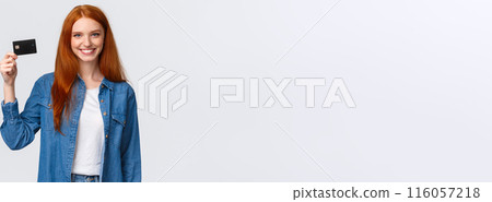 Bank, finance and education concept. Cheerful redhead girl working part-time, receive her first paycheck, holding credit card and smiling confident, standing white background delighted Bank, finance and education concept. Cheerful redhead girl working part-time, receive her first paycheck, holding credit card and smiling confident, standing white background delighted 116057218