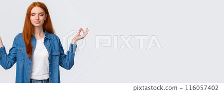 Patience, zen and modern lifestyle concept. Peaceful, calm and relieved happy smiling redhead woman meditating, hold hands sideways in lotus pose, practice yoga, white background Patience, zen and modern lifestyle concept. Peaceful, calm and relieved happy smiling redhead woman meditating, hold hands sideways in lotus pose, practice yoga, white background 116057402
