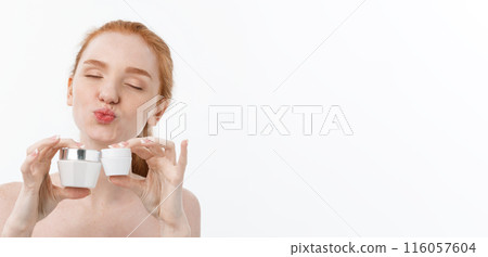 portrait of beautiful woman smiling while taking some facial cream isolated on white background with copy space. 116057604