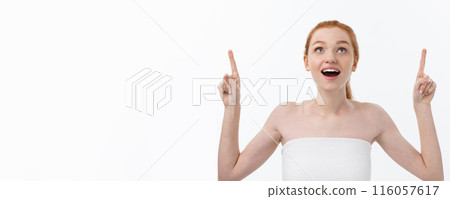 Portrait of young redhead female with perfect freckled skin showing something interesting at copy space wall for your advertising content. Portrait of young redhead female with perfect freckled skin showing something interesting at copy space wall for your advertising content. 116057617