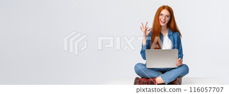 Dont worry, all done, everything under control. Confident happy and relaxed redhead girl saying all okay, show ok gesture while sit on floor with legs crossed, holding laptop, white background 116057707