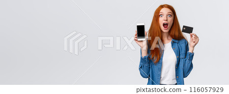 Waist-up portrait excited, astonished and thrilled redhead female student holding credit card, showing smartphone display, application, drop jaw impressed, looking camera astounded, white background Waist-up portrait excited, astonished and thrilled redhead female student holding credit card, showing smartphone display, application, drop jaw impressed, looking camera astounded, white background 116057929