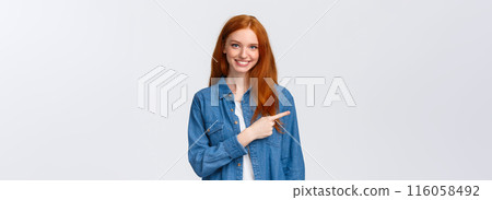 Here what need. Cheerful redhead woman in denim shirt, pointing finger left copy space, smiling recommend good product, review service, indicating website, standing white background Here what need. Cheerful redhead woman in denim shirt, pointing finger left copy space, smiling recommend good product, review service, indicating website, standing white background 116058492