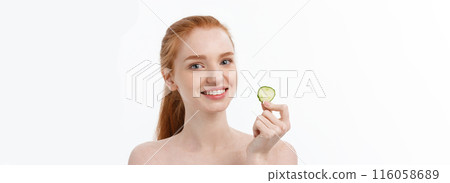 Close up beauty portrait of a smiling beautiful half naked woman holding cucumber slices at her face isolated over white background Close up beauty portrait of a smiling beautiful half naked woman holding cucumber slices at her face isolated over white background 116058689