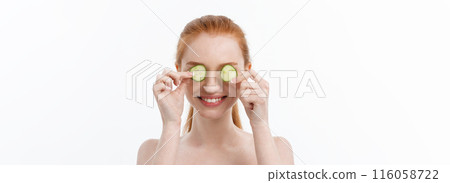 Close up beauty portrait of a smiling beautiful half naked woman holding cucumber slices at her face isolated over white background 116058722