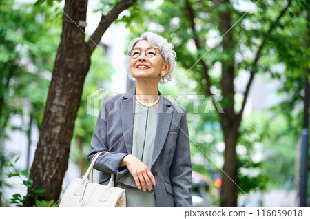 Senior woman with a bag going out 116059018