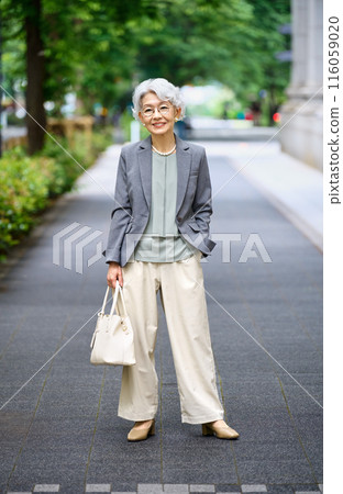 Senior woman with a bag going out 116059020