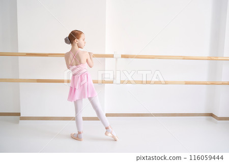 Young ballet girl at studio lesson. Training performance. Stretching exercise 116059444
