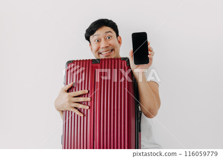 A man is holding a suitcase and a cell phone 116059779
