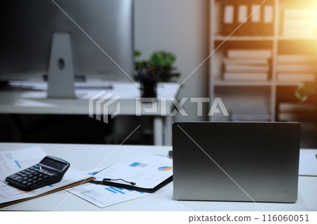 Laptop computer with opened lid on table in meeting room of office workspace. Laptop computer with opened lid on table in meeting room of office workspace. 116060051