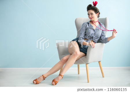 Beautiful retro girl with slender legs sits in a chair.Vintage woman. Beautiful retro girl with slender legs sits in a chair.Vintage woman. 116060135