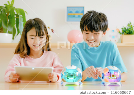 Boys and girls in the upper grades of elementary school learning STEAM while playing with a spherical robot_1 116060667