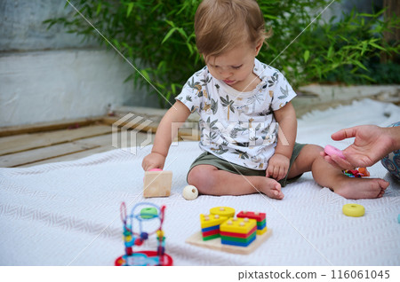 Little toddler playing with educational toys outdoors Little toddler playing with educational toys outdoors 116061045
