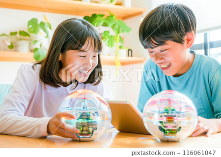 Boys and girls in the upper grades of elementary school learning STEAM while playing with a spherical robot_4 116061047