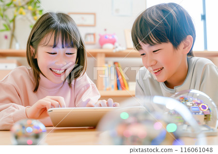 Boys and girls in the upper grades of elementary school learning STEAM while playing with a spherical robot_5 116061048