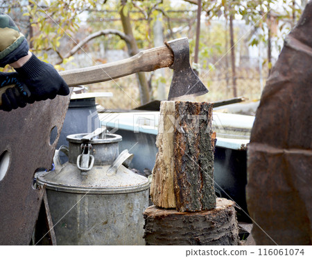 male hands in black gloves hold an ax for chopping wood 116061074