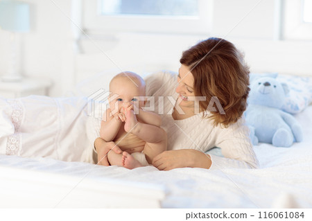 Mother and baby on a white bed Mother and baby on a white bed 116061084