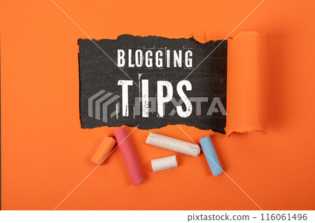 Blogging Tips. Text under torn orange paper on a blackboard Blogging Tips. Text under torn orange paper on a blackboard 116061496