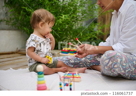 Toddler playing with mother during learning activity outdoors Toddler playing with mother during learning activity outdoors 116061737