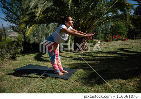 Woman practicing yoga outdoors on a sunny day 116061876
